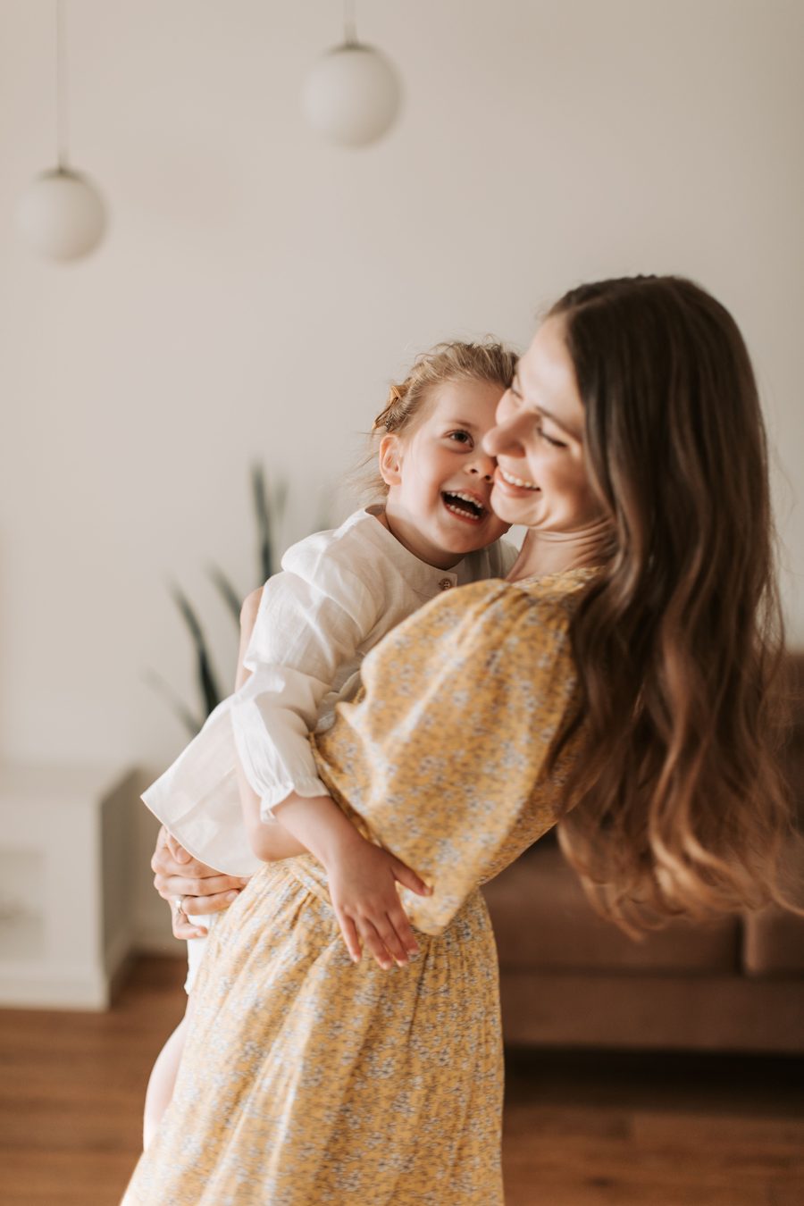 Illustrative photo of a mother and daughter laughing together at home